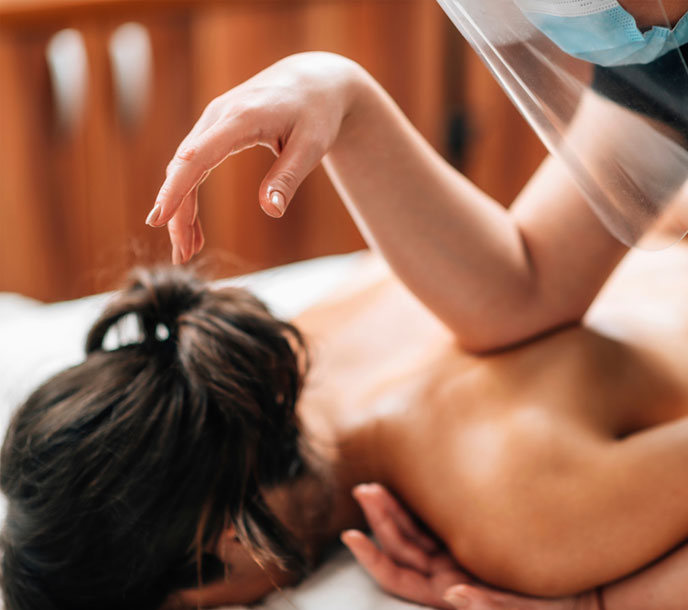 A woman getting a therapeutic Balinese Massage with the forearms of the therapist